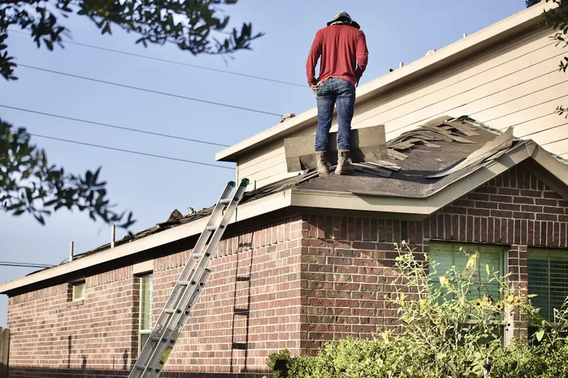 Professional roofer working on a residential roof in The Knolls